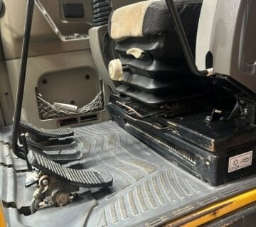 Close-up of construction equipment cabin with seat and controls. - For Sale