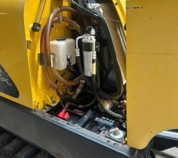 Close-up of hydraulic system in yellow construction equipment for sale. - For Sale